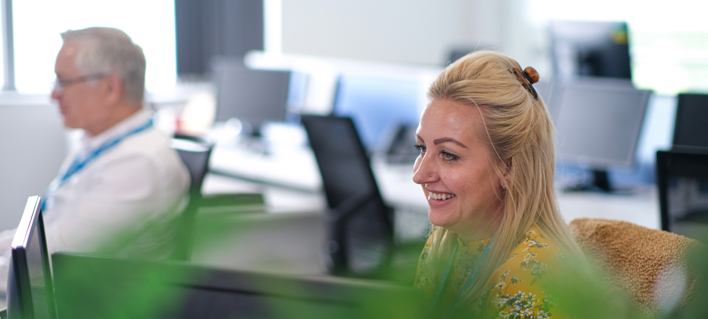 woman at office desk smiling